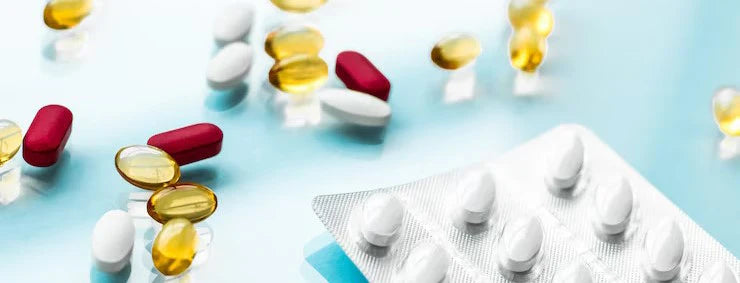 Colorful pills and capsules on a light blue background